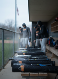 Composite bats in warmers in dugout